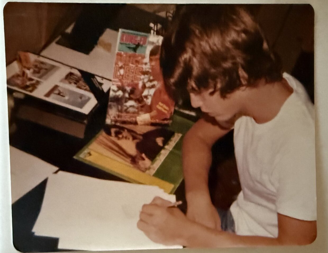 Teenage Doug Mahnke drawing at a desk, Bruce Lee posters on the wall behind him